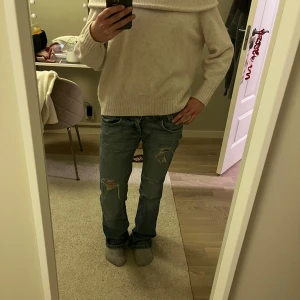 Beige offshoulder tröja - Säljer en mysig ljusbeige offshoulder tröja med ribbade detaljer och den är stickad. Tröjan har långa ärmar och en lös passform.