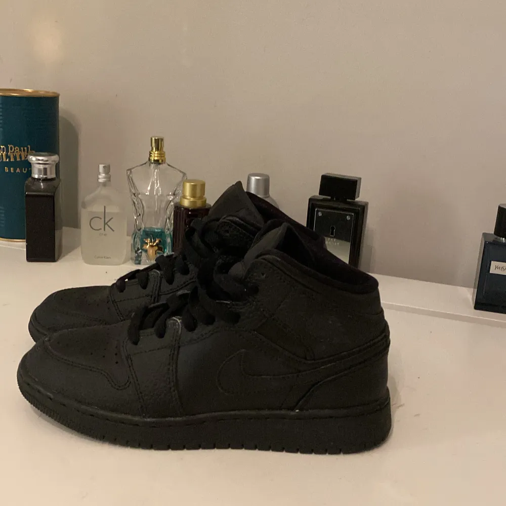 Snygga helsvarta Nike Air Jordans med klassisk design och snörning. Perfekta för en stilren look.. Kengät.