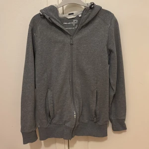 Grå hoodie | Pelle P - Säljer en grå hoodie från Pelle P i storlek M men det passar som en S i herstorkel. Notera att det finns ett litet slitage vid dragkedjan. Nypris 1200kr