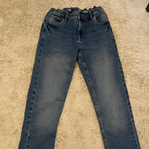 Blå jeans från LAB Industries - Säljer ett par klassiska blå jeans från LAB Industries. De har en straight passform och är tillverkade i denim. Jeansen har fem fickor och en knappgylf. Syns att dem är använda på benet annars inte så mycket. Storlek 170. 