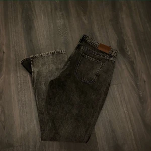 Grå jeans med vintage-look - Snygga grå jeans med en cool vintage-tvätt. De har en klassisk femficksdesign och en läderpatch baktill. Perfekta för en avslappnad stil.