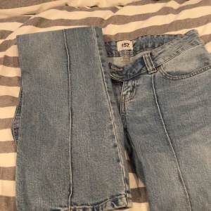 Blå jeans från 157 - Snygga blå jeans från 157 med klassisk design. De har en rak passform och är perfekta för en avslappnad stil. Jeansen har fem fickor och bälteshällor.