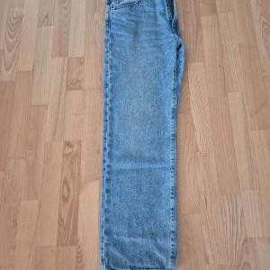 Levi's 505 Straight Jeans - Säljer ett par klassiska Levi's 505 Straight jeans i ljusblå denim. De har en rak passform och är perfekta för en avslappnad stil. Jeansens ikoniska lädermärke sitter på baksidan av midjan.