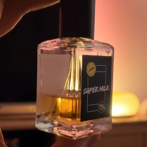 Super Milk parfym från Lush - Säljer en flaska Super Milk parfym från Lush. Flaskan är fyrkantig med en svart etikett och texten 'Super Milk'. Perfekt för dig som älskar unika dofter.