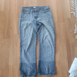 Blå jeans med broderade fickor från Sure - Snygga blå jeans från Sure med unika broderade detaljer på bakfickorna. De har en klassisk femficksdesign och en bekväm passform. Tydligt tecken på slitningar mellan benen men inget som synes när de sitter på! 