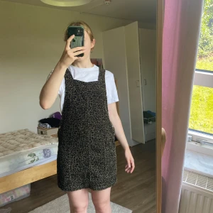 Hängselklänning leopard - Hängsleklänning från Bershka i fint skick! Den är som ny. Enda defekten är att det kan finnas lite lösa trådar. Fin att ha som ”kjol” under stickad tröja.