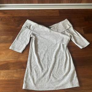 Säljer en superfin grå offshoulder klänning från Gina Tricot. Den är ribbad och har trekvartsärm, perfekt för både vardag och fest. Klänningen är i ett mjukt och bekvämt material som sitter snyggt på kroppen. Passar perfekt till höst och vår! 🥰🥰