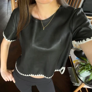 Svart t-shirt med dataljer - Läder imitation med vita stickade detaljer Supernajs till hösten