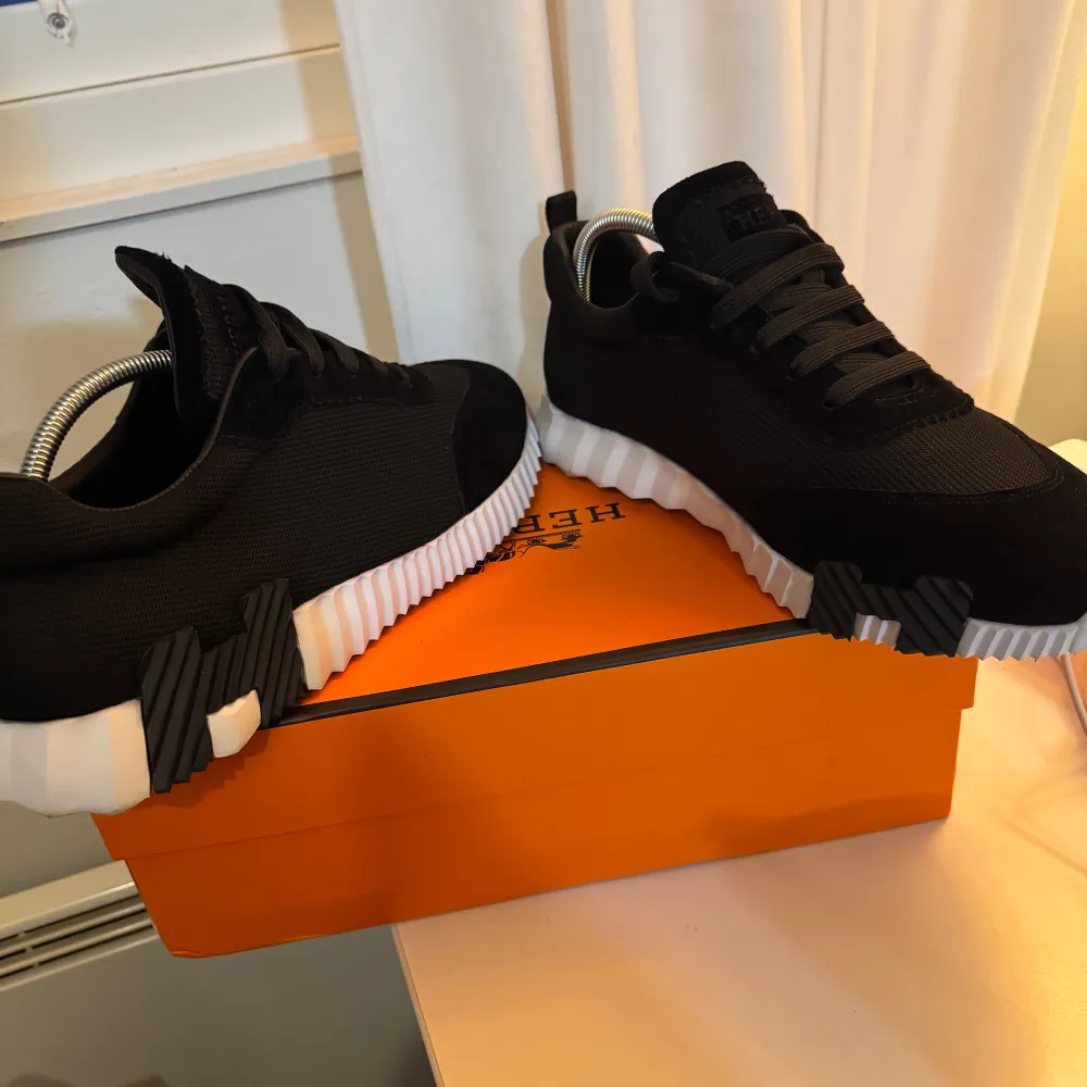 Snygga svarta sneakers med en kontrasterande vit sula. Skorna har en stilren design med snörning och en unik sula med svarta detaljer. Perfekta för en modern och sportig look.. Kengät.