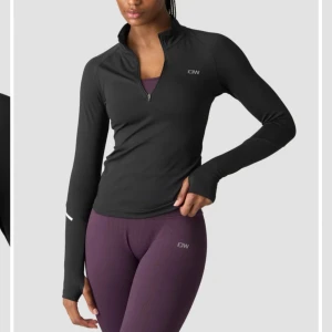 Svart långärmad träningströja från ICANIWILL - Snygg och funktionell svart långärmad träningströja från ICANIWILL. Tröjan har en halv dragkedja framtill och är perfekt för träning under kyligare dagar. Den är designad för att ge en tight passform och har diskreta logodetaljer. Nypris 599kr 