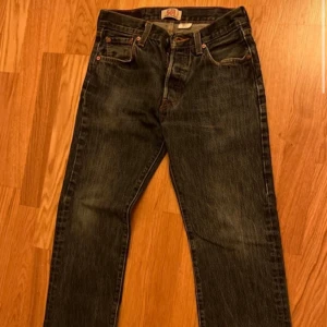 Levi's 501 jeans - Klassiska Levi's 501 jeans i mörkblå denim. Dessa jeans har en rak passform och är tillverkade av 100% bomull. Knappgylf. Begagnade utan synliga defekter.