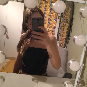 Svart tubtoppen jätte snygg lädertopp😍 - Snygg svart tubtopp i glansigt material. Perfekt för en kväll ute eller en fest. Enkel och stilren design som passar till många olika outfits💕säljer då jag råkade köpa 3 stycken😂skriv för frågor eller bättre bilder🫶🏻💕ny pris 80kr mitt pris 40kr