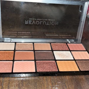 ögonskuggspalett  - en ögonskuggspalett från Revolution med 15 nyanser i varma toner. Knappt använd. Säljer resten av sminket i andra inlägg för billiga priser! Skicka om du har frågor! 💕