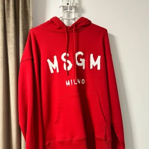 Röd hoodie från MSGM - Snygg röd hoodie från MSGM med stor logga på framsidan. Den har en klassisk känguruficka och justerbar huva. Perfekt för en avslappnad stil.