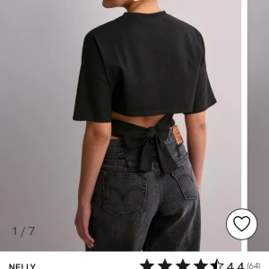 Svart croppad topp från Nelly - Snygg svart croppad topp från Nelly med korta ärmar och knytning i ryggen. Perfekt för en trendig look.💕