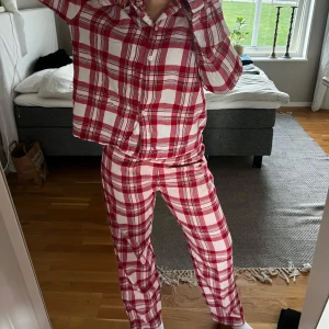 Röd/vit flanellpyjamas  - Byxorna är mer använda än skjortan. 