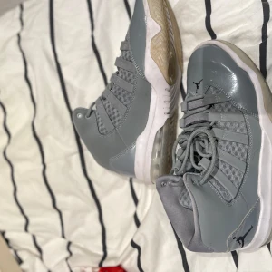 Grå Nike Air Jordans - Snygga grå Nike Air Jordans med snörning och en stilren design. Skorna har en hög modell med en kombination av syntet och skinnmaterial. Perfekta för dig som vill ha en sportig och trendig look. Dom är oxå äkta 