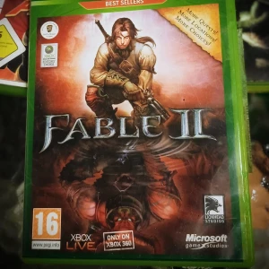 Fable II för Xbox 360 - Fable II är ett actionrollspel utvecklat av Lionhead Studios för Xbox 360. Spelet erbjuder en öppen värld med många valmöjligheter och uppdrag. Det är en del av Xbox 360:s 'Best Sellers' och har en åldersgräns på 16 år.
