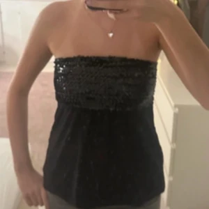 glittrig topp - Snygg svart tubtopp med glittriga paljetter upptill. Perfekt för nyår, postar såklart innan isåfall. Toppen är axelbandslös och har en tight passform upptill och lösare ner till. Skriv om ni har fler frågpr🩷🩷