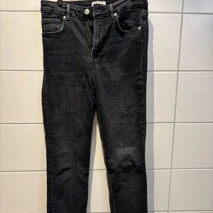 Svarta jeans från Zara - Snygga svarta jeans från Zara med en klassisk femficksdesign. De har en rak passform med lite bootcut och är tillverkade i ett slitstarkt denimtyg. Perfekta för en stilren look. Färgen är svart/mörkgrå. 