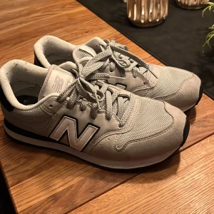 Grå New Balance sneakers - Snygga grå New Balance sneakers med vit och svart detaljering. Skorna har en klassisk design med snörning och en bekväm sula. Perfekta för vardagsbruk.   ///priset är förhandlingsbart vid snabb affär!!!