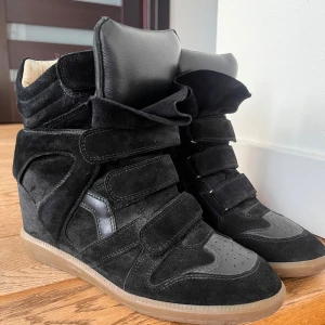 Svarta sneakers från Isabel Marant - Snygga svarta sneakers från Isabel Marant med kilklack och kardborreband. Ny pris 5900💗Säljer eftersom de var lite stora på mig som brukar ha 39! Skulle säga att dom passar som st 40. Med följer låda och dustbag! Pris kan diskuteras💕