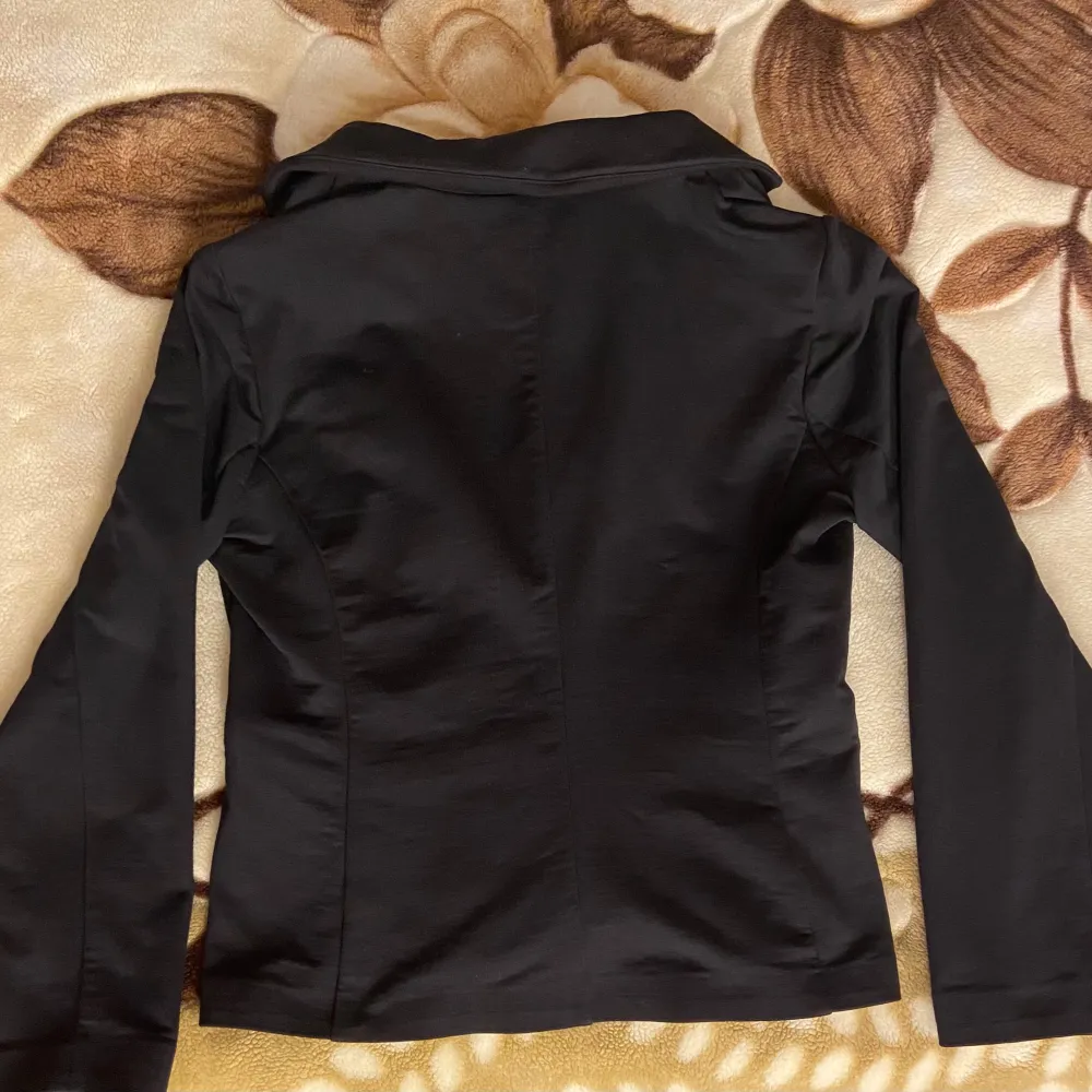 Klassisk svart blazer som passar alla tillfällen, fin att ha till nyår! Från märket Saint Tropez, äkta. Har en kavajkrage, en knappknäppning, 2 stora fickor framtill (insydda, ej funktionella) och en normal passform. Långa ärmar. Skick: Mycket fint skick. Nypris: 699 kr . Puvut & Bleiserit.