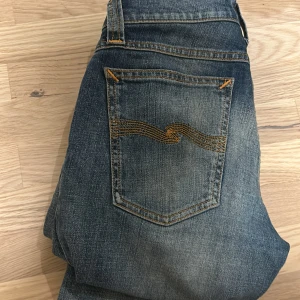 Blå jeans från Nudie Jeans - Ett par snygga nudie jeans storlek 27W och 32L skick är 9/10 varan skickas dagen efter någon har köpt jeansen