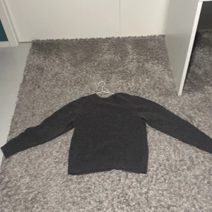 Grå stickad tröja från Uniqlo - Säljer en stilren och bekväm grå stickad tröja från Uniqlo. Perfekt för kyliga dagar med sin mjuka och varma känsla. Tröjan har en klassisk design med långa ärmar och ribbstickad krage. Passar både till vardags och mer uppklädda tillfällen. Pris  kan diskuteras. 