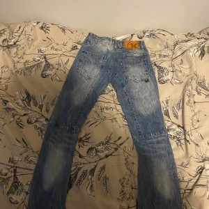 Blå jeansbyxor - Säljer ett par snygga blå jeansbyxor i bra skick. De har en klassisk femficksdesign med knappar och en cool tvättad look. Perfekta för vardagsbruk och kan matchas med nästan vad som helst. Passar både till skolan och fritiden!