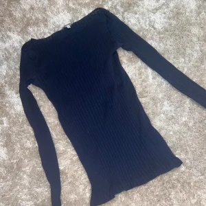 Marinblå ribbad topp från Intimissimi - Säljer en stilren marinblå ribbad topp från Intimissimi i storlek S. Den har en tight passform och långa ärmar, perfekt för både vardag och fest. Materialet är mjukt och stretchigt, vilket gör den superbekväm att bära. Passar perfekt till höst- och vintergarderoben! 