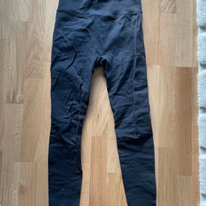Svarta träningsbyxor  - Säljer ett par svarta träningsbyxor i mycket bra skick. De är högmidjade och har en tight passform, perfekta för träning eller en avslappnad dag. Materialet är stretchigt och bekvämt, vilket gör dem till ett måste i garderoben. Passar till alla säsonger!