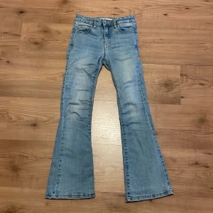 Ljusblå bootcut jeans - Säljer ett par ljusblå bootcut jeans från Cubus i storlek 140. Skönt material. Lagade men de syns knappt när man har på sig dom. Säljer då de är för små. 