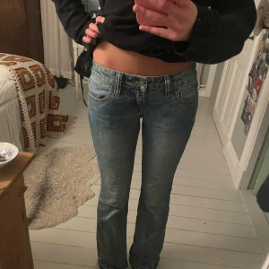 Blå jeans i bootcut-stil - Säljer mina svinsnygga lågmidjade bootcut jeans från Brandy Melville! Har sprättat upp dom där nere för att passa min längd, tycker att det blir en fin detalj! Dom är i fin fint skick🫰🏼