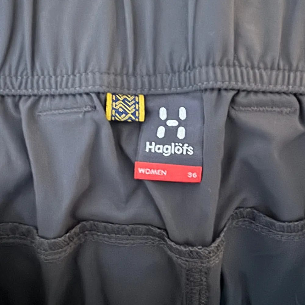 Säljer ett par svarta byxor från Haglöfs i storlek 36. De är perfekta för utomhusaktiviteter med flera praktiska fickor och en bekväm passform. Byxorna har en elastisk midja och är i mycket bra skick.. Farkut & Housut.
