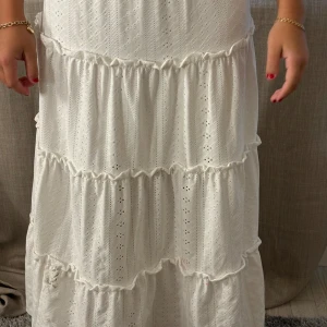 Vit långkjol med volanger - Säljer en superfin vit långkjol med volanger. Den är i bra skick men har några små fläckar som syns på bilderna!