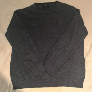 Mörkgrå merinoull tröja från Bruun & Stengade - Säljer en stilren mörkgrå tröja från Bruun & Stengade i storlek XXL fast passar som XL. Tröjan är i mycket bra skick inga fel och perfekt för både höst och vinter. Den har långa ärmar och är gjord i ett mjukt material som känns skönt mot huden. Passar både till vardags och lite finare tillfällen.