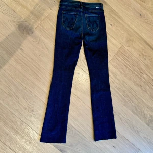 Mörkblå jeans från Mother, stl 25- NYA - Säljer ett par riktigt snygga mörkblå jeans från designmärket Mother. De har en klassisk femficksdesign och är i ett stretchigt denimtyg som ger en bekväm passform. Perfekta för både vardag och fest! Användbara både till vardag och fest. De har en bootcut-modell och en rå, avskuren kant vid bensluten.                    Mycket trendiga just nu, slutsålda överallt.  Endast provade. Aldrig använda pga fel storlek.  Nypris ca 4200:- så skynda att fynda! 