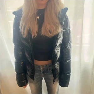 Svart glansig jacka - Svart glansig vinterjacka från Refrigiwear. Jättefint skick, så som ny. Nypris runt 4000kr men går inte att köpa längre. Storlek S men passar även XS. Verkligen jättefin men säljer då jag har en annan vinterjacka. Tryck gärna pä köp nu. 