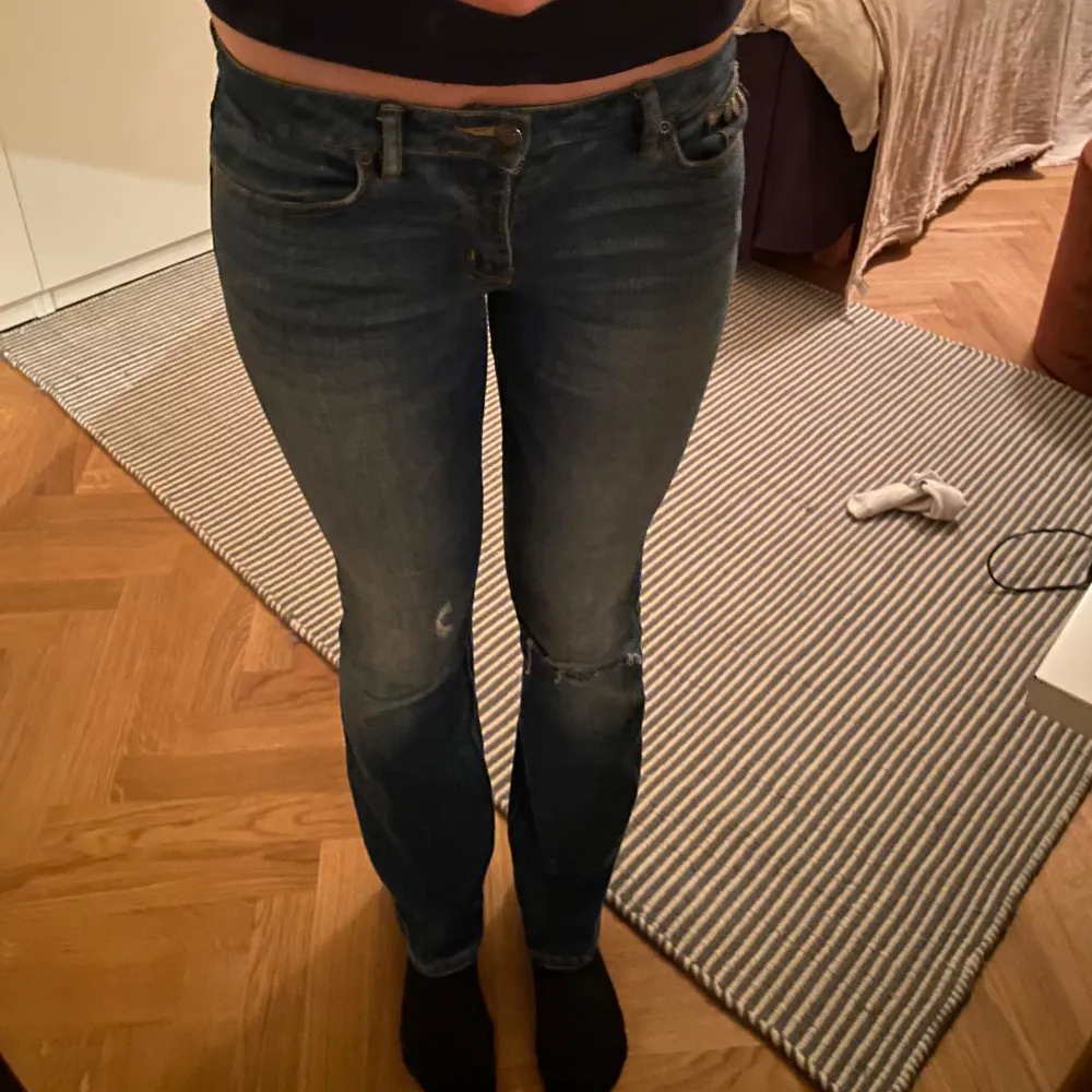 Säljer ett par snygga blå jeans i bra skick. De har en tight passform och är logmidjade. Jeansen har en klassisk femficksdesign och är perfekta för både vardag och fest. De har en liten slitning på ena benet och detaljer vid fickorna. . Jeans & Byxor.