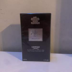 Säljer en lyxig Creed Aventus Eau de Parfum i 100ml flaska. Den kommer i en elegant svart förpackning med silverdetaljer. Perfekt för den som vill ha en sofistikerad och tidlös doft. Flaskan är oöppnad och i perfekt skick. Passar både till vardags och speciella tillfällen. 🌟