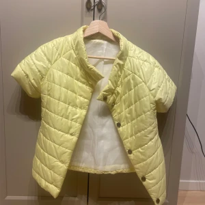 Gul quiltad trekvartsärmad jacka - Säljer en superfin gul quiltad jacka med korta ärmar. Perfekt för vår och sommar! Herno-liknande med knappar framtill och är i mycket bra skick. 