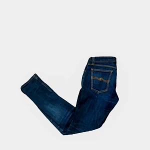 Mörkblå jeans från Nudie Jeans - Säljer ett par snygga mörkblå jeans från Nudie Jeans i storlek 30/32. Jeansen är i bra skick och har en väldigt snygg slimmad passform.