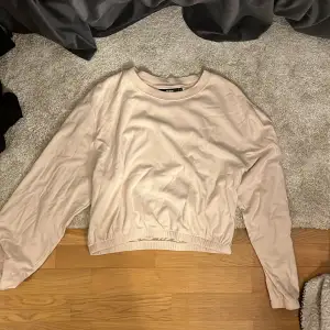 Säljer en stilren beige tröja från Bik Bok. Tröjan har långa ärmar och en rund halsringning. Perfekt för en avslappnad look.