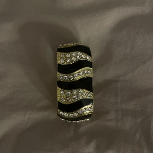 Vintage glitter armband  - Säljer ett svart guldigt vintage glitter armband med vita strass diamanter på💗aldrig använt 