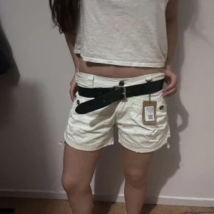 Vita shorts - Snygga vita shorts och knappar på fickorna. Perfekta för sommardagar. De har en avslappnad passform och är tillverkade i ett lätt material.