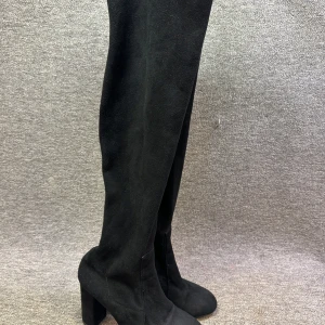 Svarta höga stövlar med klack - Snygga svarta stövlar i mocka med hög klack och dragkedja på sidan. Perfekta för en stilren look.