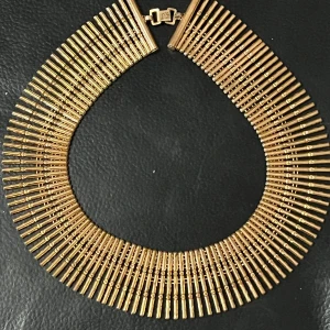 Guldhalsband med stavdesign - Elegant guldhalsband med en unik stavdesign som ger ett lyxigt och iögonfallande utseende. Halsbandet har en säker låsning och är perfekt för att ge en glamorös touch till din outfit.