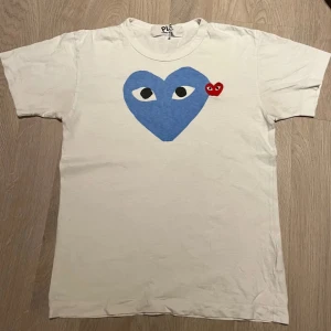 Vit t-shirt med blått hjärta från Comme des Garçons - Säljer en stilren t-shirt från Comme des Garçons i storlek S