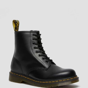 Dr Martens - Väl använda - Klassiska svarta boots med snörning och gul söm längs sulan. Perfekta för en stilren look med robust känsla. De har en högre skaft och en dragflik baktill för enkel påtagning. Väl använt skick. 